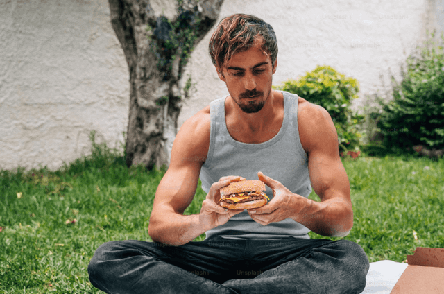 Hombre fitness comiendo una hamburguesa